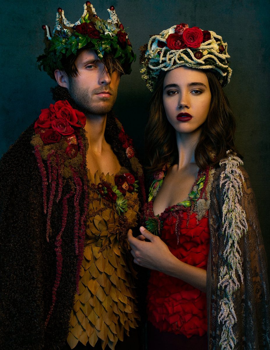 A couple wearing matching floral crowns and floral collars.